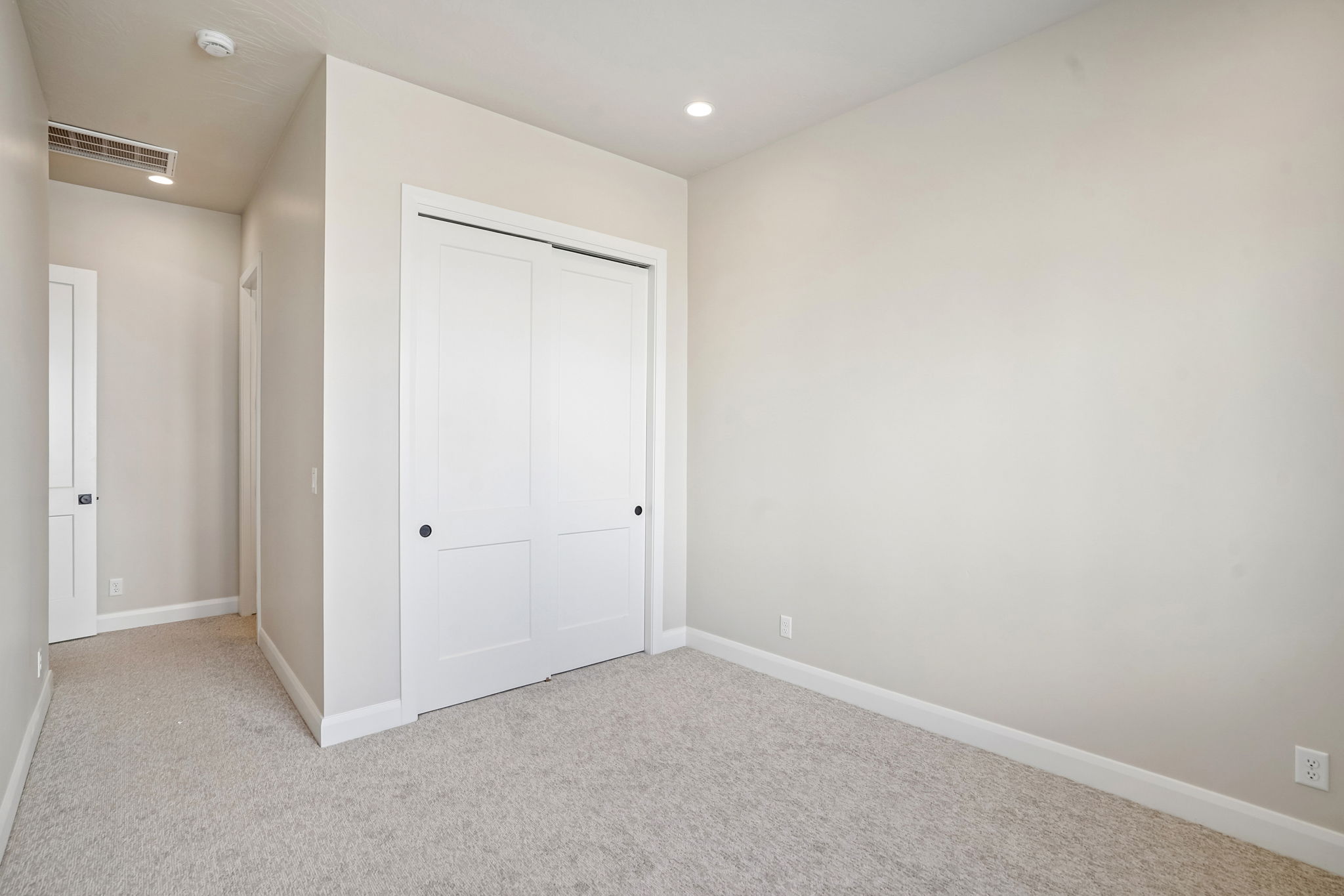 Unfurnished bedroom in the Pacific II by Cole West featuring soft neutral finishes, plush carpeting, and a spacious closet with sliding doors.
