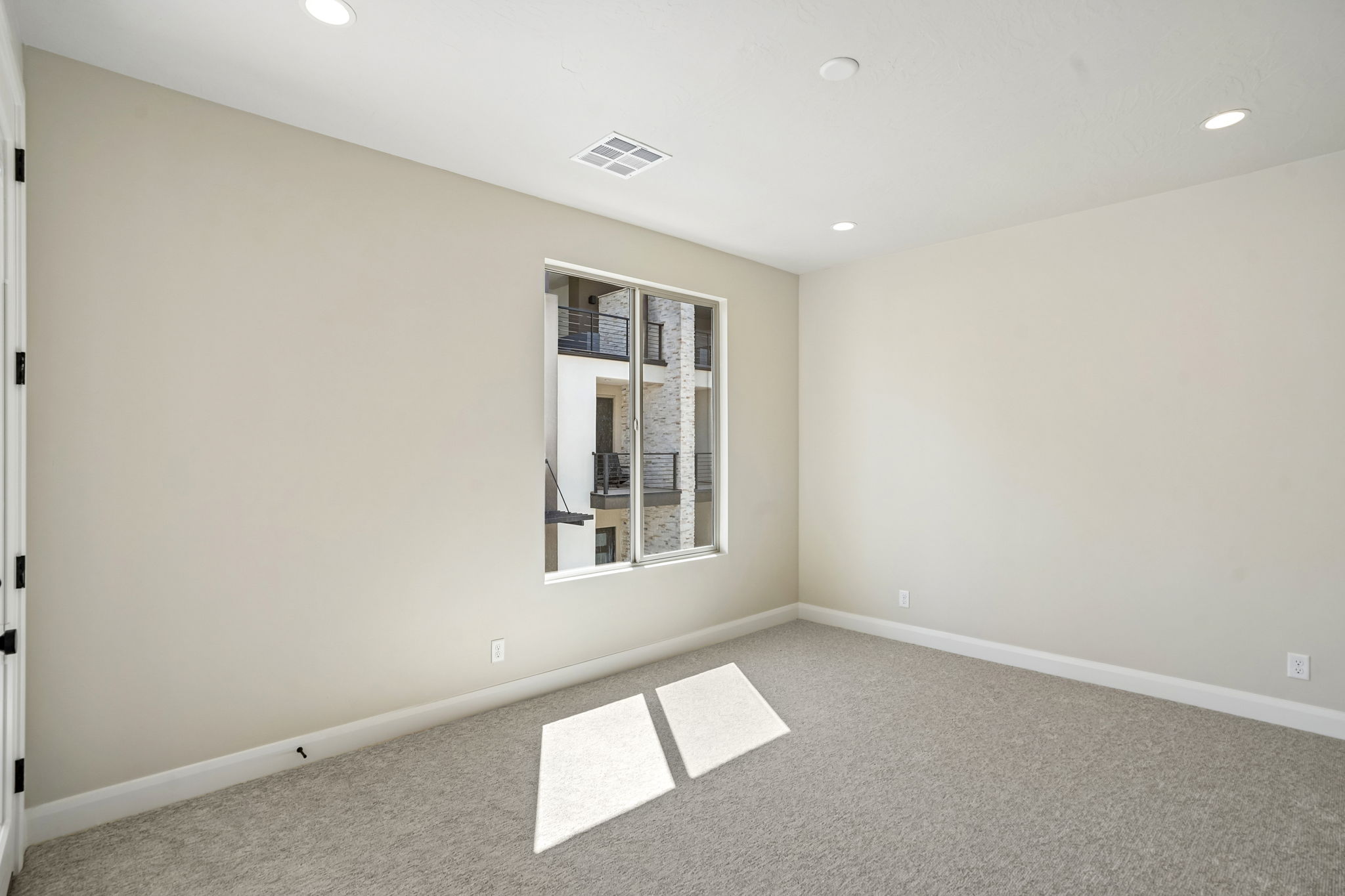 Naturally lit bedroom in the Pacific II by Cole West featuring a large window, soft neutral carpeting, and clean modern finishes.