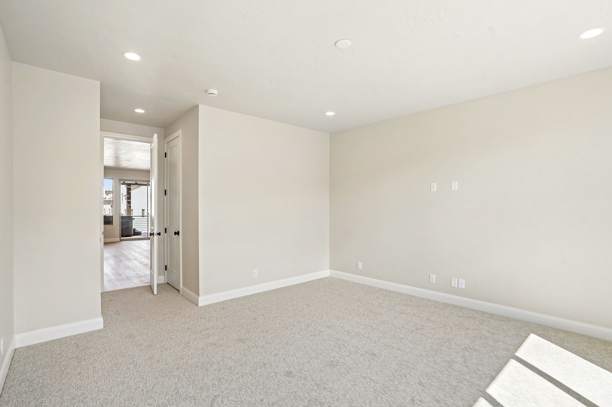 Open and spacious bedroom in the Pacific II at Desert Color in St. George, Utah, featuring neutral finishes, plush carpeting, and abundant natural light.