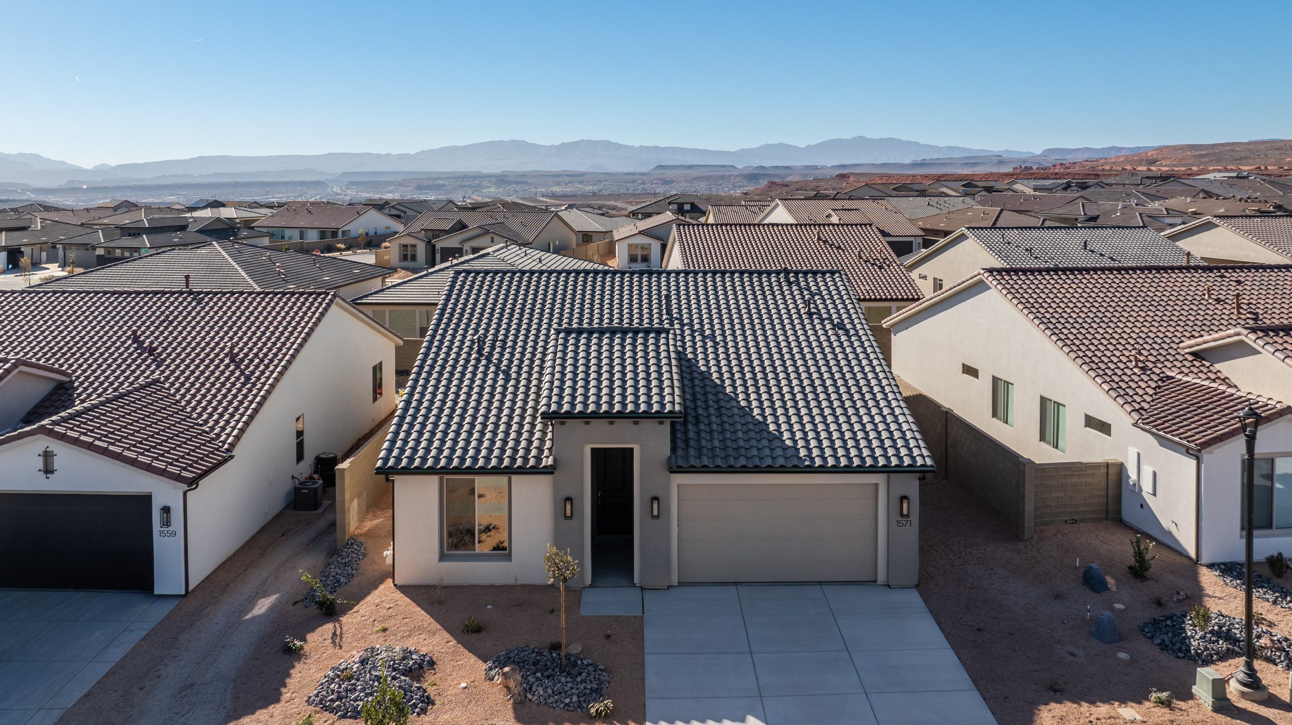 Aerial front view of the Mojave single-story home at Solis by Cole West in Washington, Utah, featuring a modern exterior, tile roof, and attached garage.