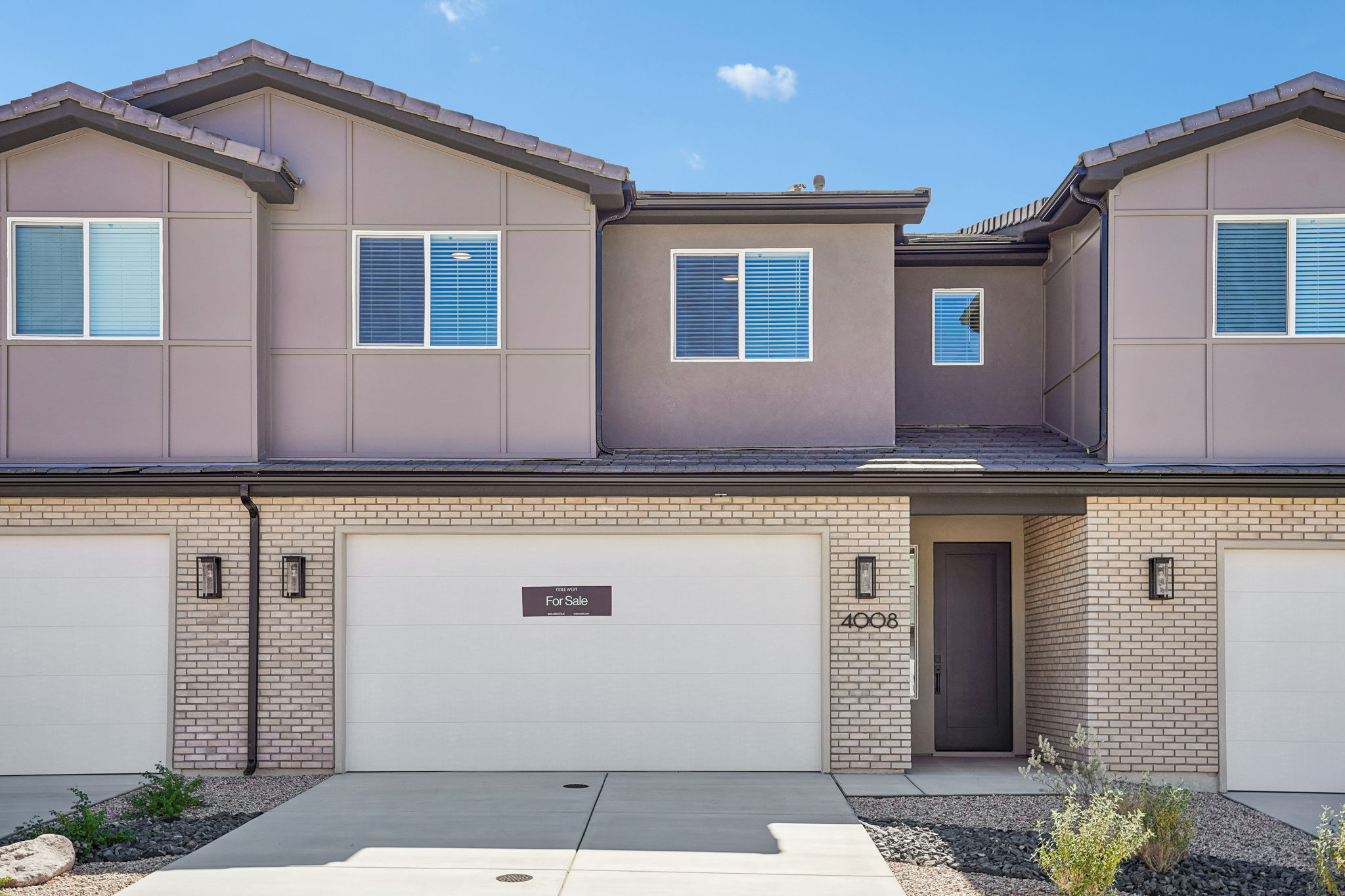 Modern two-story Sunburst townhome at Rise by Cole West in Washington, Utah, featuring contemporary architecture, brick accents, and an attached garage.