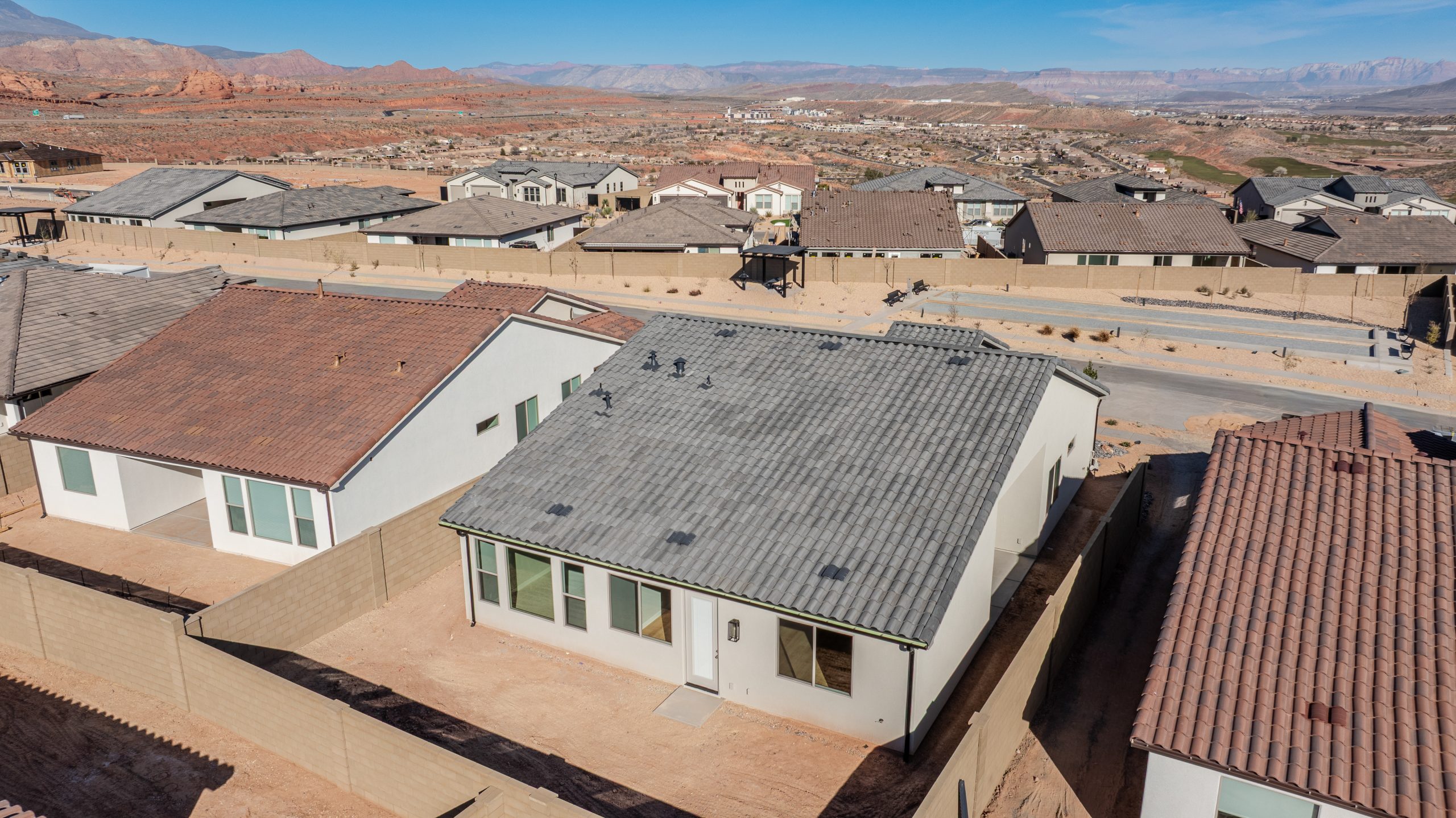 Aerial rear view of the Mojave home at Solis showcasing a private backyard, desert landscaping, and surrounding Southern Utah red rock scenery.