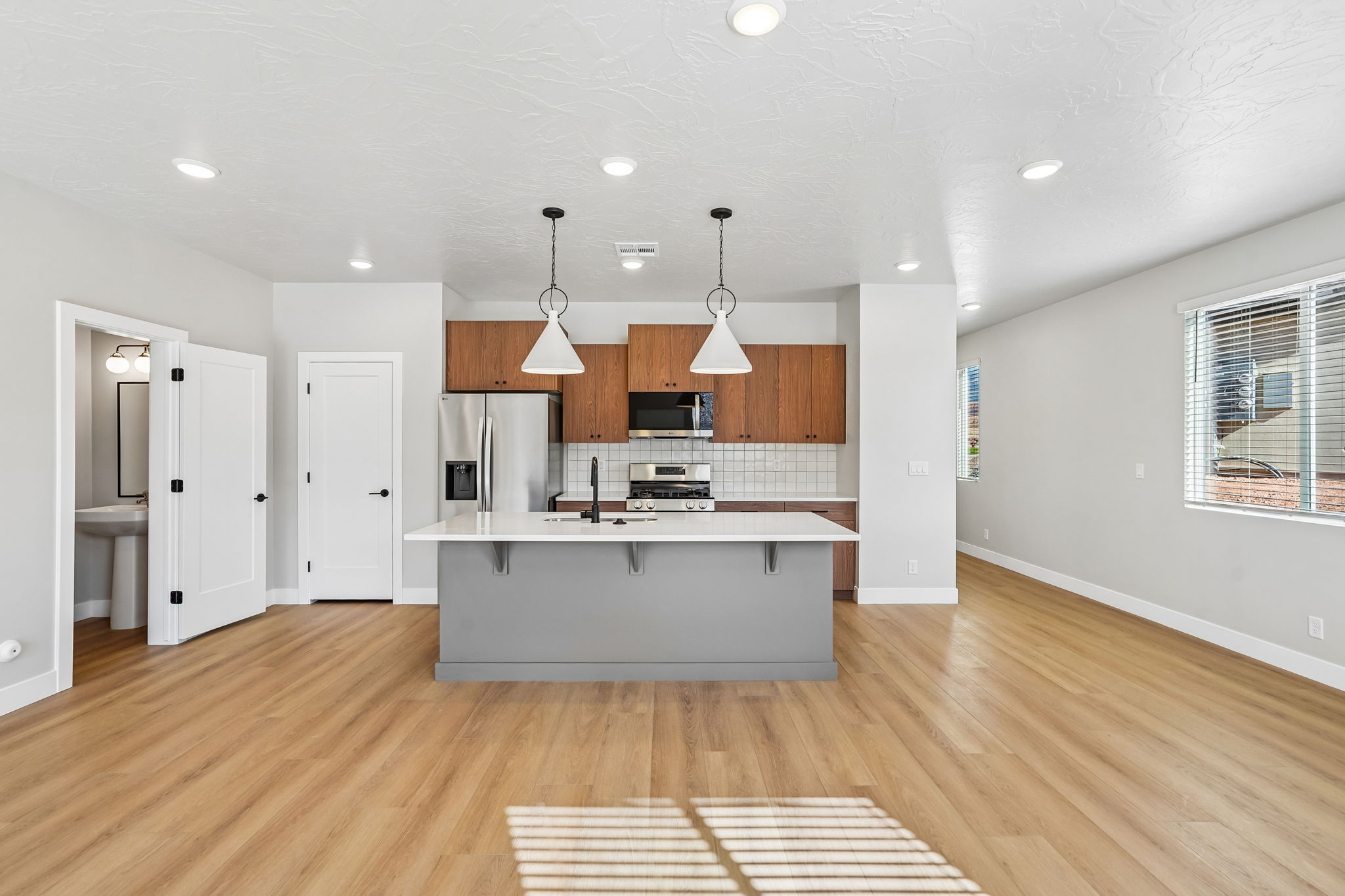 Stylish kitchen featuring a spacious island, pendant lighting, and stainless steel appliances.