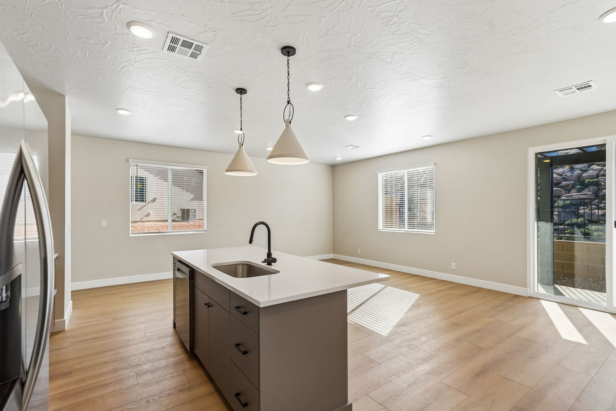 Modern kitchen with a large center island, warm cabinetry, and an adjoining dining space.