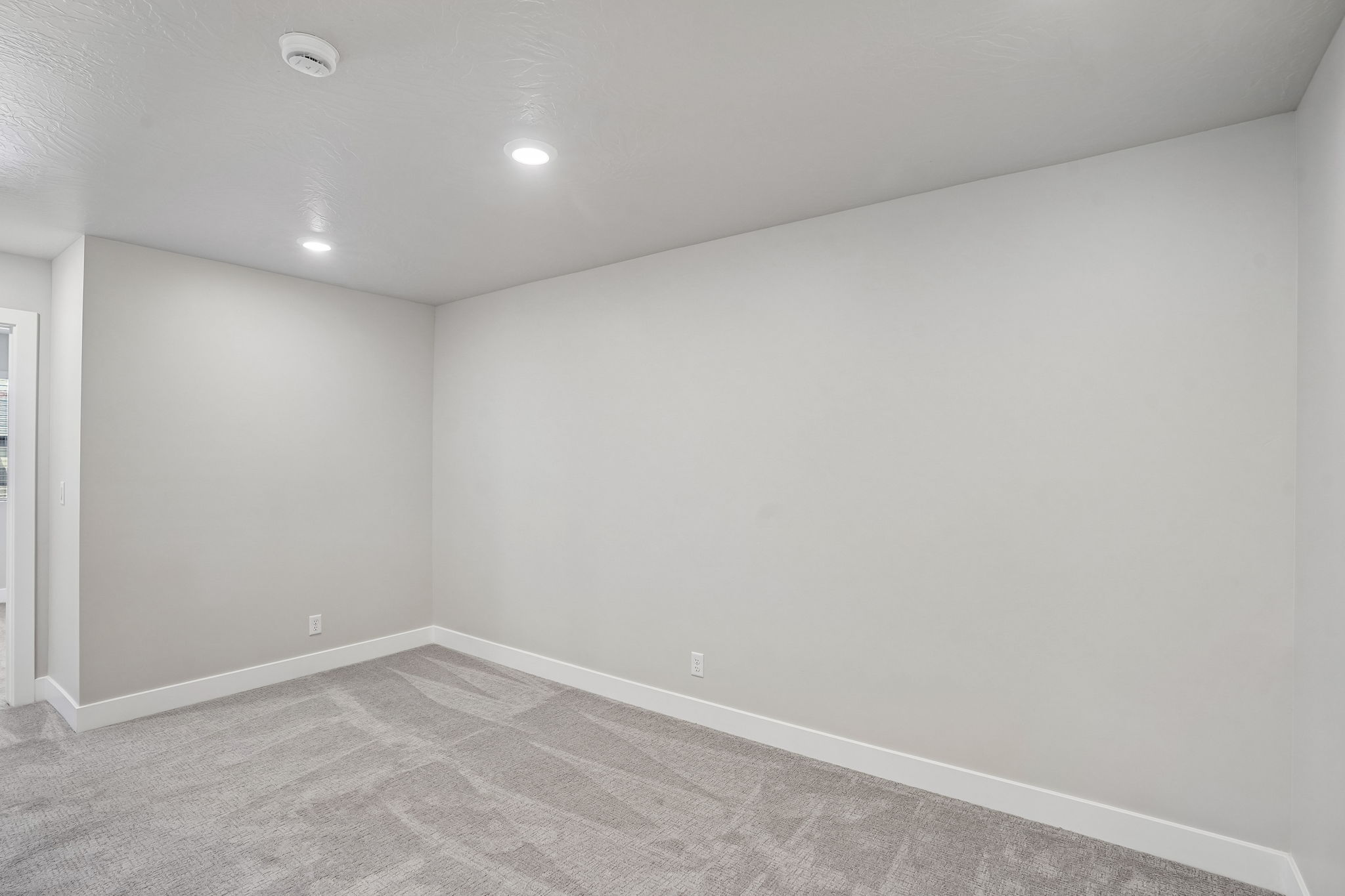 Spacious upstairs loft in the Sunburst floor plan by Cole West, featuring neutral carpeting, recessed lighting, and flexible living space.